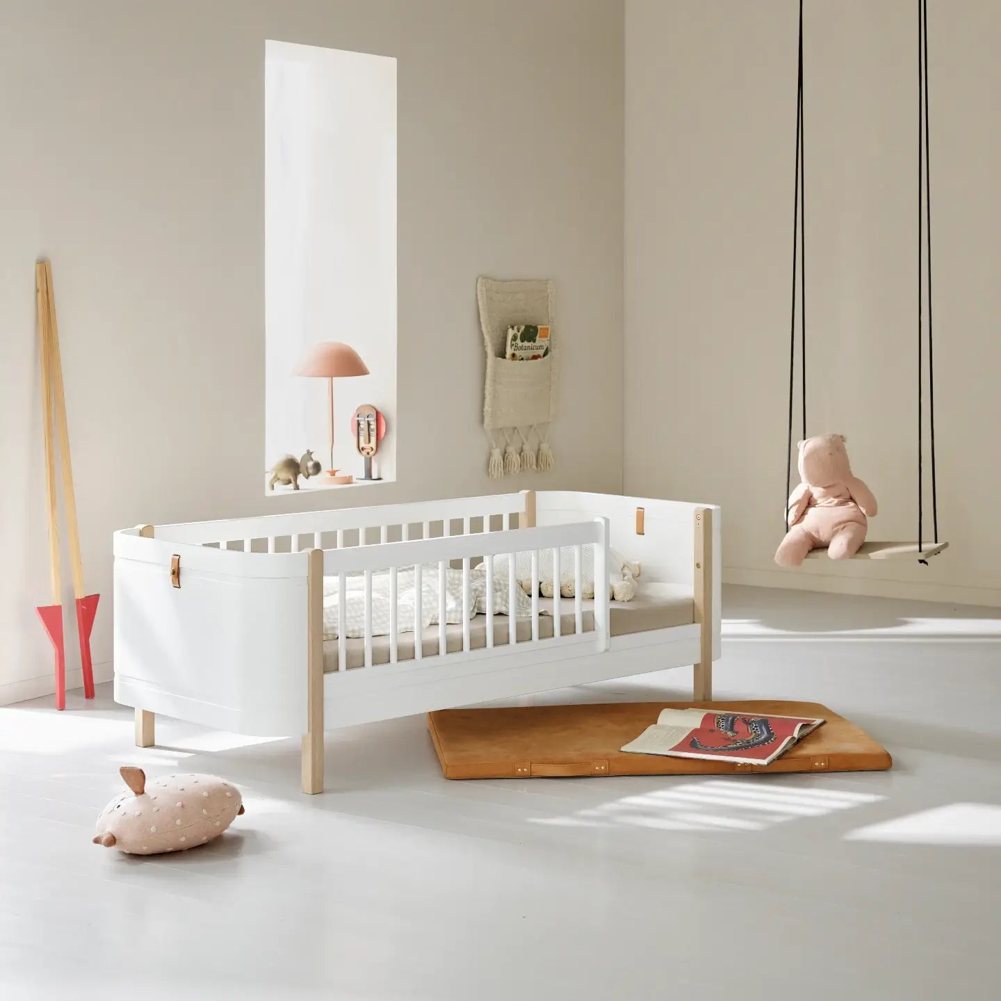 Modern baby room with white/oak Oliver Furniture Mini+ Junior Bed, wooden floor, and minimal decor.