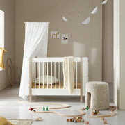 Nursery room with a white crib, toys, and decorative elements.