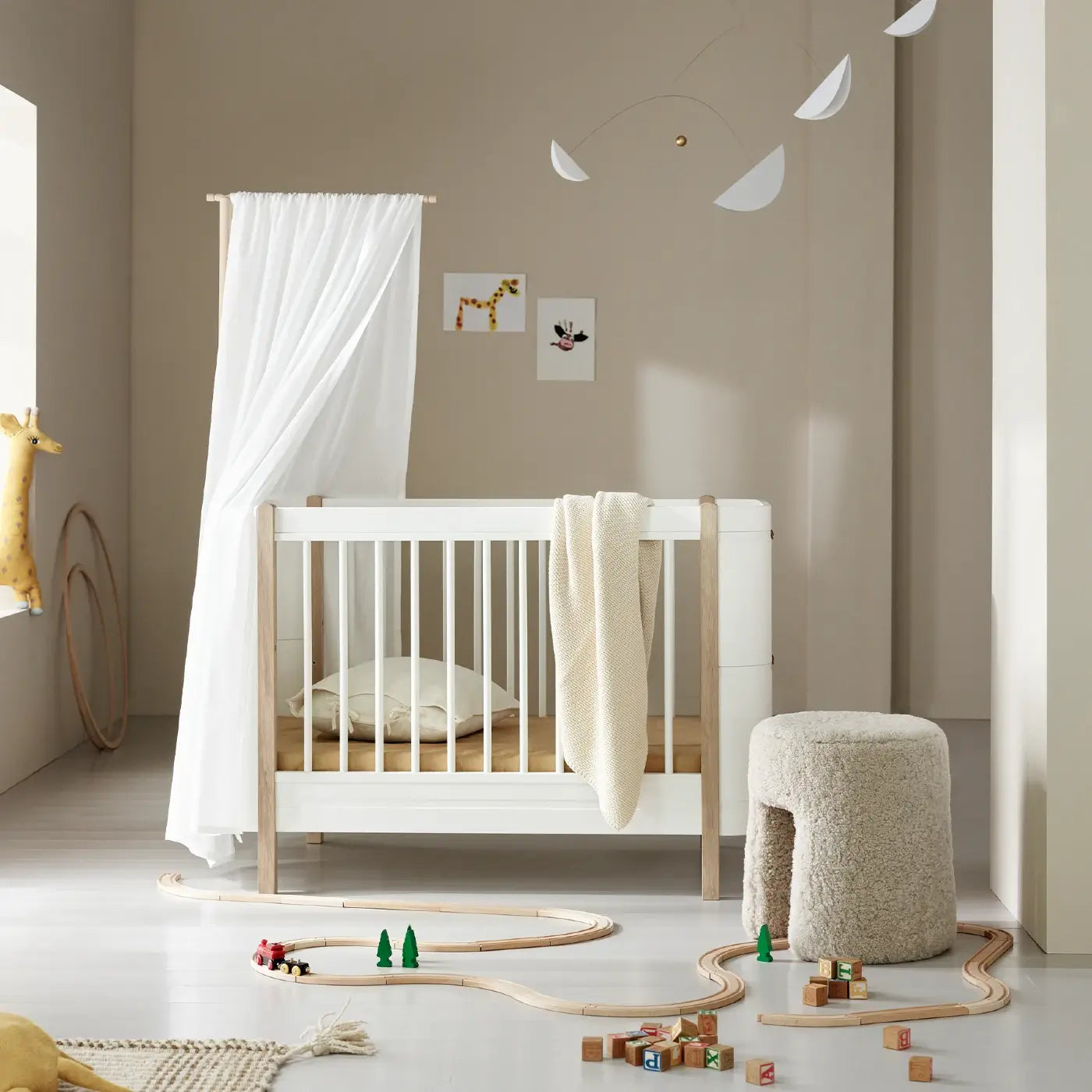 Nursery room with a white crib, toys, and decorative elements.