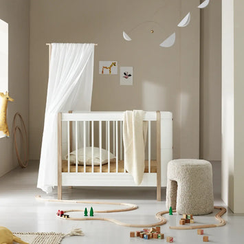 Nursery room with a white crib, toys, and decorative elements.